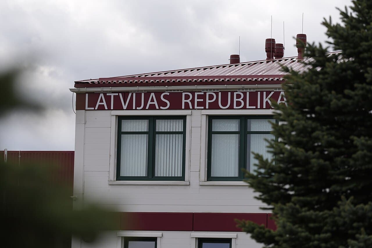 Latvia-Belarus border, Oct 5, 2026 - armed escorts, cameras taken
