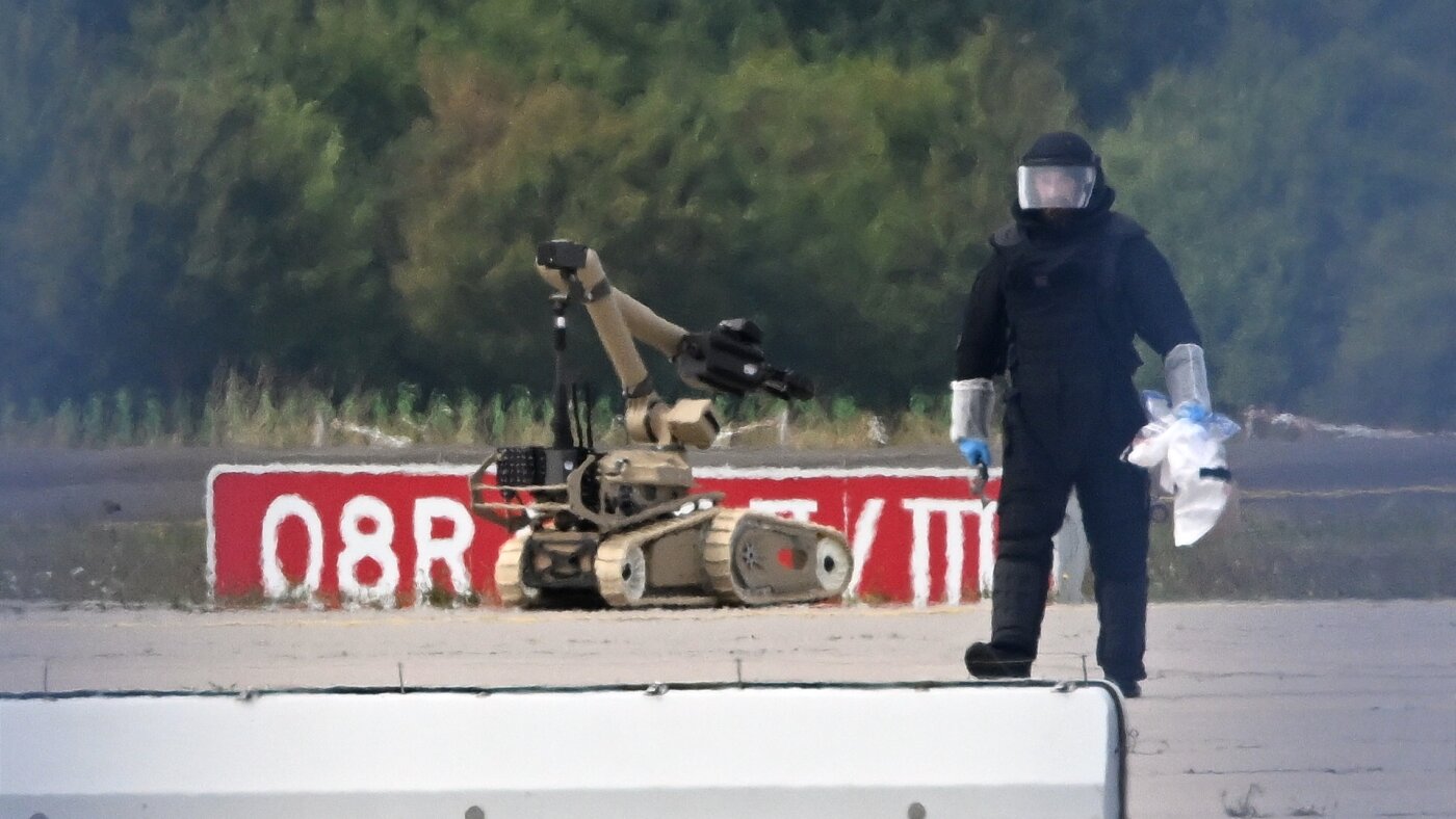 A bomb-disposal technician and robot on the runway at Leipzig/Halle Airport