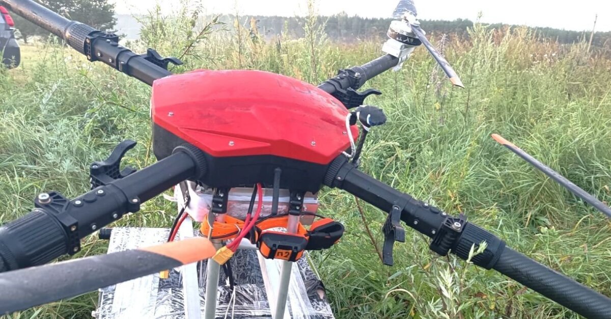 One of the recovered cargo drones near Norviliškės, Šalčininkai district, 29 July 2026, with a broken propeller and cargo strapped beneath. Photo: VSAT, via 15min.lt.