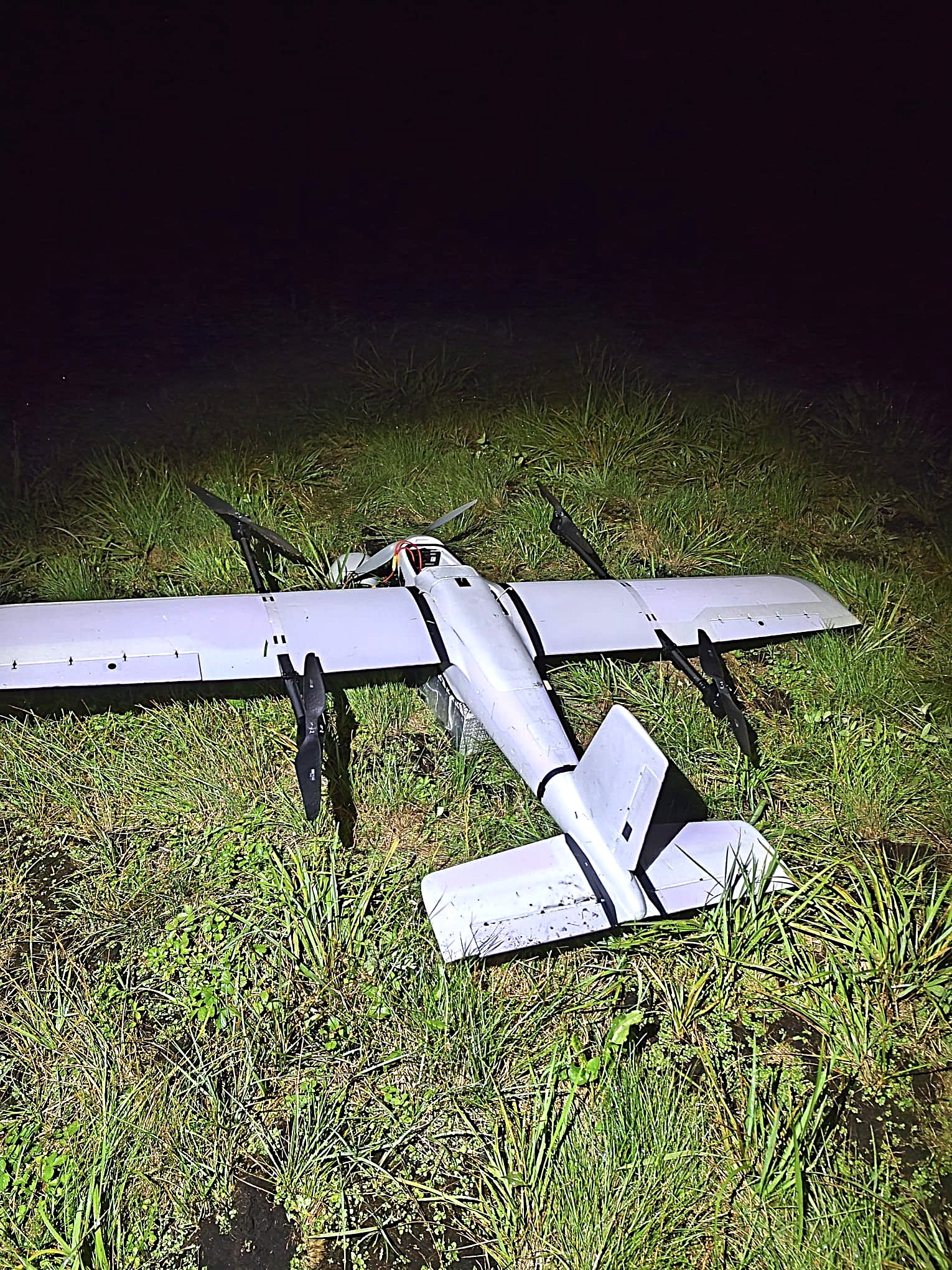 The fixed-wing contraband drone found in grass near Tausiūnai village, Šalčininkų district, on the night of 26 July 2026. Photo: VSAT.