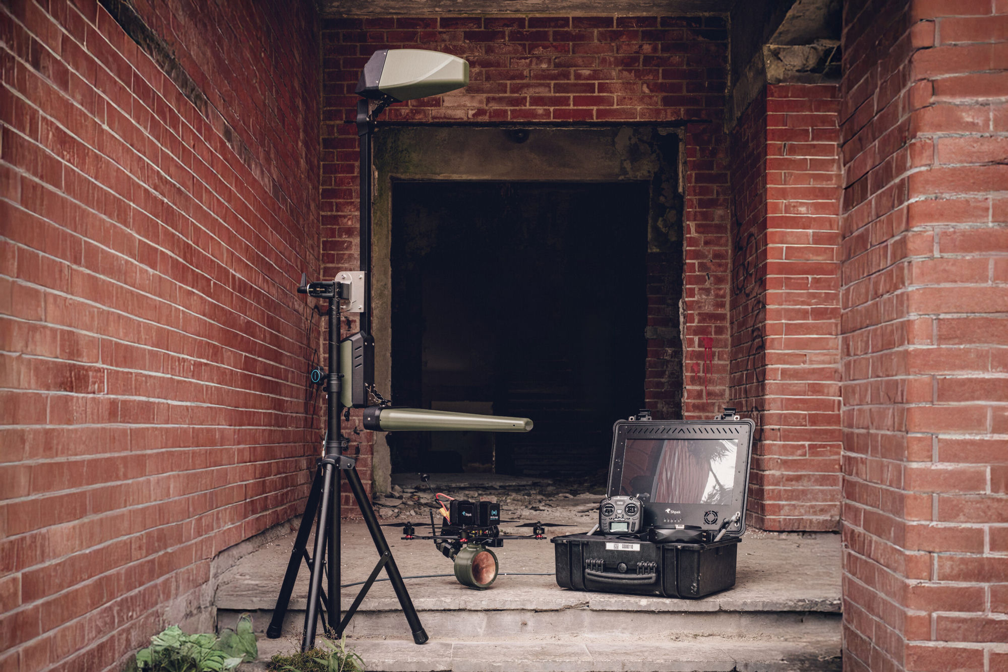 RSI Europe's Shpak FPV drone and ground-control kit, staged in a brick doorway